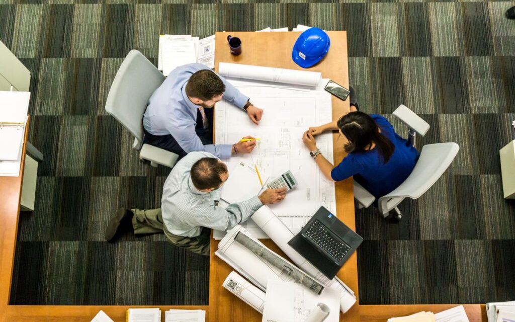Project team reviewing contract documents and plans around a table