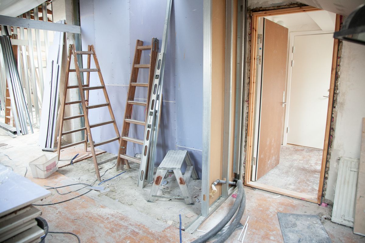 Residential renovation works in progress with ladders and plastering