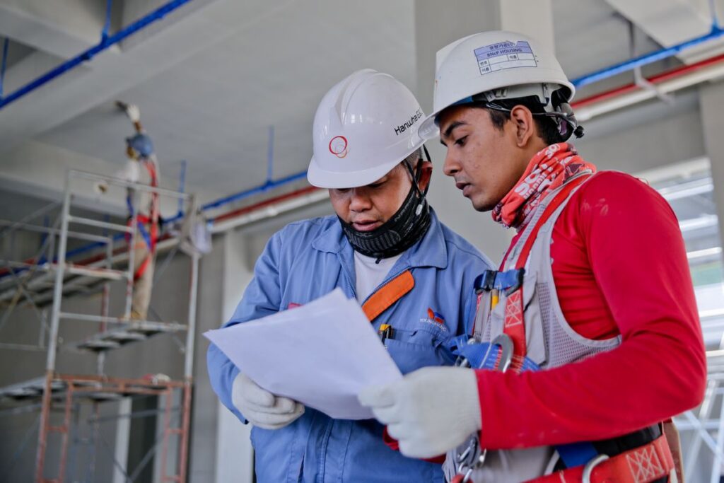 Two site engineers reviewing a construction programme on site
